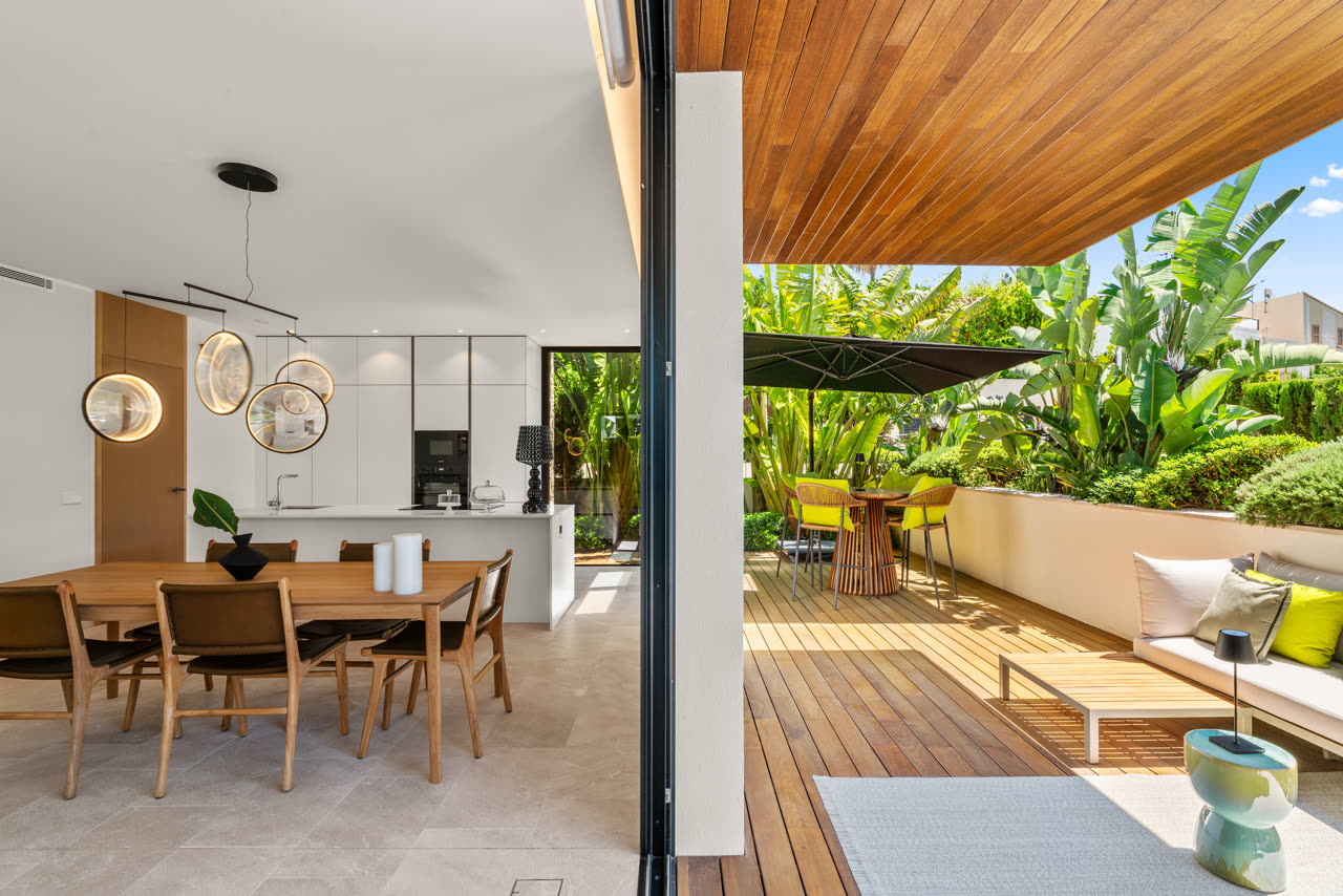 Terrace dining area under mature Mediterranean planting